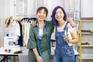 ritratto di sorridente asiatico alla moda libero professionista sarta squadra nel loro artistico laboratorio studio per moda design e capi di abbigliamento attività commerciale industria foto