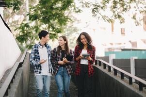 giovane Università studenti e un' femmina alunno gruppo opera a il città universitaria parco foto