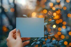 ai generato womans mano detiene piccolo vuoto blu carta con bokeh sfondo foto