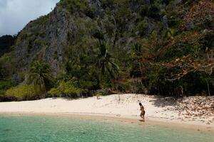 donna a piedi su un' tropicale spiaggia. foto