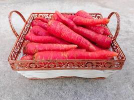 carota verdura. fresco e grande rosso carote nel il cestino foto