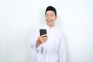 allegro asiatico musulmano uomo ridendo mentre Tenere Telefono isolato foto