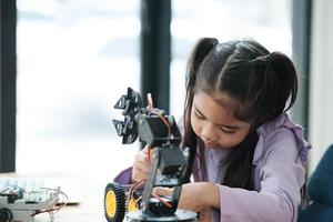 stelo formazione scolastica concetto. asiatico giovane ragazza apprendimento robot design. foto