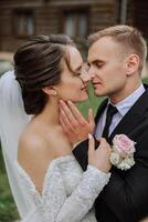 il sposo baci il suo sposa su il tempio contro il sfondo di bellissimo natura su un' estate giorno. arte. selettivo messa a fuoco. foto