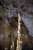 il grotta è carsico, sorprendente Visualizza di stalattiti e stalagmiti illuminato di luminosa luce, un' bellissimo naturale attrazione nel un' turista posto. foto