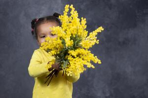 poco africano americano ragazza con giallo fiori su un' grigio sfondo. foto