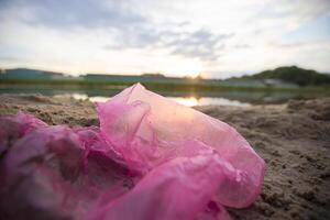 cellofan pacchetto su il fiume banca. ambientale inquinamento.rifiuti su il spiaggia foto