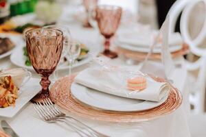 un' Visualizza di nozze tavoli, Attenzione per servendo, con fiore disposizioni, costoso posate, piatti con bianca tovaglioli. foto
