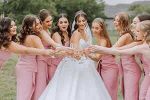 foto sposa con sua amici potabile Champagne a partire dal occhiali. ritagliata tiro di un' bellissimo giovane sposa e sua damigelle d'onore avendo Champagne prima il nozze.