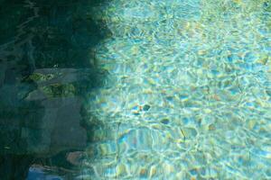 acqua nel nuoto piscina riflettendo luce del sole. foto