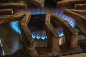 gas consumo concetto. stufa illuminato con blu leggero fiamma. foto