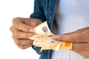 donna di mani conteggio fatture di uno mille argentino pesos. foto
