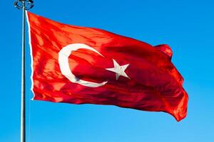 agitando Turco bandiera isolato su blu cielo sfondo. foto
