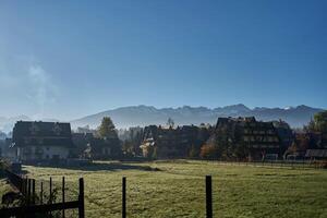 il case nel zakopane contro il sfondo di montagne coperto con mattina nebbia a alba foto