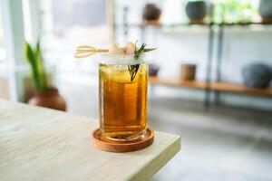 fresco freddo bevanda di lychee tè su un' tavolo con un elegante bar nel il sfondo. foto