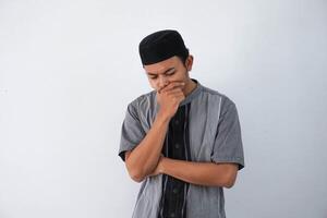 pensiero giovane asiatico musulmano uomo Tenere mento pensiero gesto, guardare per idea indossare grigio musulmano Abiti isolato su bianca sfondo foto