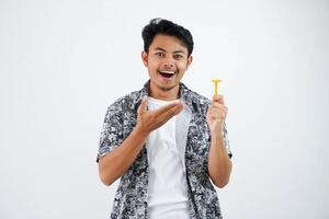 sorridente o contento giovane asiatico uomo puntamento a il rasoio con il suo dito indossare nero camicia isolato su bianca sfondo foto
