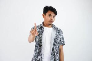 positivo giovane asiatico uomo indossare nero camicia fiducioso mostrare dito su isolato su bianca sfondo foto