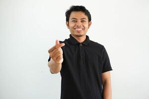 sorridente o contento asiatico uomo mostrando gesto cuore forma mani o attraversamento il suo indice dito e pollice il simbolo Sarangae, Sarangheo, saranghaeo indossare nero polo t camicia isolato foto