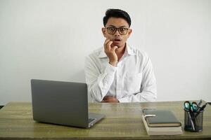 giovane asiatico uomo d'affari nel un' posto di lavoro sorpreso e scioccato mentre guardare Giusto, indossare bianca camicia con bicchieri isolato foto