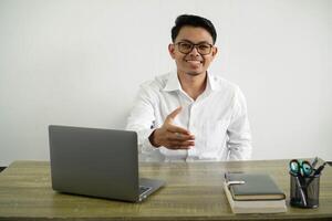 giovane asiatico uomo d'affari nel un' posto di lavoro tremante mani per chiusura un' bene affare, indossare bianca camicia con bicchieri isolato foto