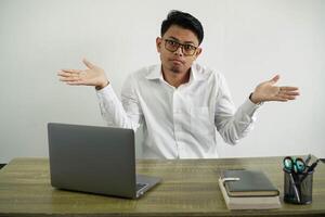 giovane asiatico uomo d'affari nel un' posto di lavoro avendo dubbi mentre raccolta mani indossare bianca camicia con bicchieri isolato foto
