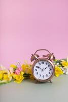 allarme orologio con primavera fiori. primavera volta, luce del giorno risparmi concetto, primavera inoltrare foto