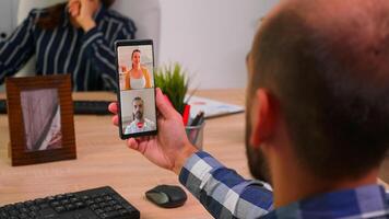 finanziario uomo d'affari avendo un' videoincontro parlando con azienda manager e esecutivo amministratore seduta su scrivania nel aziendale edificio ufficio. imprenditore utilizzando moderno tecnologia. foto