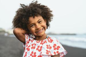 ritratto di afro americano bambino avendo divertimento su il spiaggia durante vacanza tempo foto