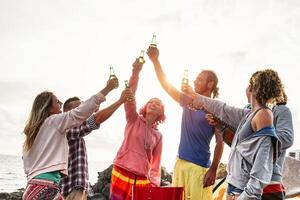 gruppo di amici fabbricazione festa e tostatura con birre a tramonto - giovane contento persone avendo divertimento a barbecue cena all'aperto - del Millennio, estate, vacanza e gioventù vacanze stile di vita concetto foto