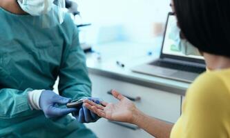 medico lavoratore controllo glicemia test per diabete per femmina paziente durante corona virus scoppio - assistenza sanitaria concetto foto