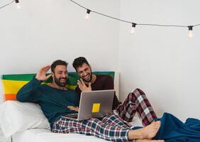 contento gay uomini coppia fare video chiamata utilizzando il computer portatile dentro letto - omosessuale amore e Genere uguaglianza nel relazione concetto foto