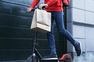 ciclista uomo consegna pasto per i clienti con elettrico scooter - ecologico veloce consegna cibo concetto foto