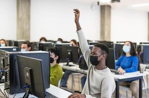 giovane studenti ascoltando un' lezione nel alto scuola mentre indossare viso maschera durante corona virus pandemia - formazione scolastica e tecnologia concetto foto