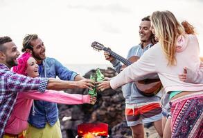 contento amici tostatura birre a barbecue cena festa - giovane persone avendo divertimento potabile e giocando chitarra a tramonto all'aperto - del Millennio, estate, vacanza e gioventù vacanze stile di vita concetto foto