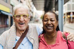 contento multirazziale anziano amici avendo divertimento mentre in attesa a il autobus stazione foto