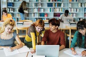 giovane Università studenti utilizzando il computer portatile e studiando con libri nel biblioteca - scuola formazione scolastica concetto foto