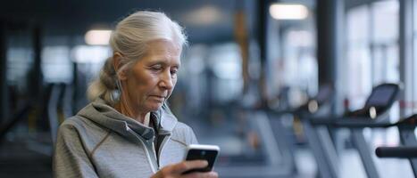 ai generato femmina anziano nel Palestra con Telefono a mano foto