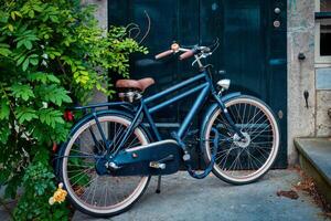 bicicletta vicino porta di vecchio Casa nel amsterdam strada foto