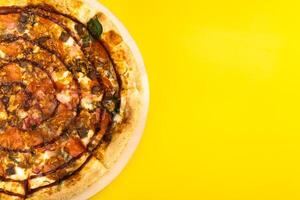 delizioso grande Pizza con Bacon e spinaci su un' giallo sfondo foto