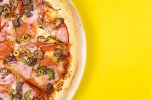 delizioso grande Pizza con vitello e funghi su un' giallo sfondo foto