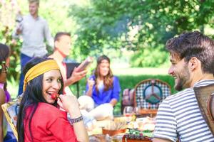 gruppo di contento amici fabbricazione un' picnic bbq nel un' parco all'aperto - giovane persone avendo un' barbecue festa godendo cibo e bevande insieme - amicizia, stile di vita, gioventù concetto - messa a fuoco su donna viso foto