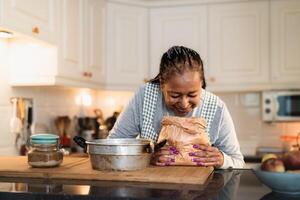 contento anziano africano donna preparazione un' fatti in casa dolce foto