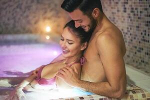 contento giovane coppia godendo insieme un' nuoto piscina terme centro giorno - romantico Gli amanti avendo un' tenero momento su vacanza nel ricorrere benessere Hotel - relazione, rilassamento e amore concetto foto