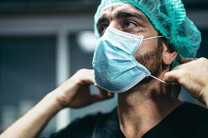chirurgo preparazione per chirurgico operazione - medico lavoratori il vero eroi durante corona virus scoppio - assistenza sanitaria e medico combattente e prevenire diffusione di pandemia foto