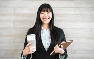 asiatico attività commerciale donna Tenere inteligente tavoletta e prendere lontano caffè al di fuori ufficio - gioventù imprenditore concetto foto