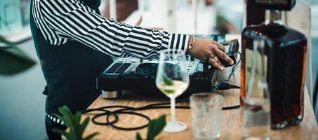 dj giocando musica con miscelatore giocatore a cocktail bar - festa vita notturna concetto foto