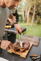 un' uomo su il strada cucinato un' bistecca su il griglia nel un' barbecue foto