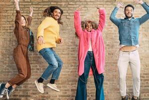 contento amici salto insieme all'aperto - del Millennio giovane persone avendo divertimento danza e festeggiare al di fuori - concetto di amicizia, celebrazione festa e gioventù stile di vita foto