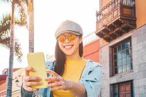 contento asiatico ragazza utilizzando mobile smartphone all'aperto - Cinese sociale influencer avendo divertimento fabbricazione video storia per nuovo tendenze sociale reti App - le persone, del Millennio generazione e tecnologia concetto foto